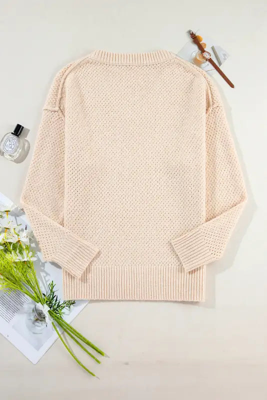 Eyelet elegance drop: pale pink knitted sweater with textured pattern and ribbed cuffs