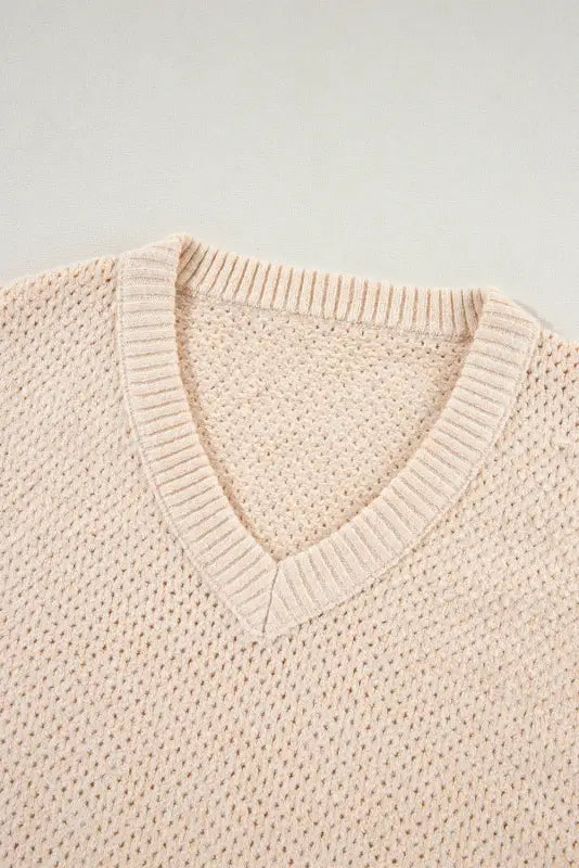 Eyelet elegance drop sweater: cream-colored v-neck knit with a textured pattern. Relax relax