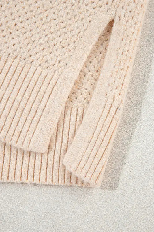 Eyelet elegance drop: cream-colored knit sweater with ribbed detailing and textured pattern