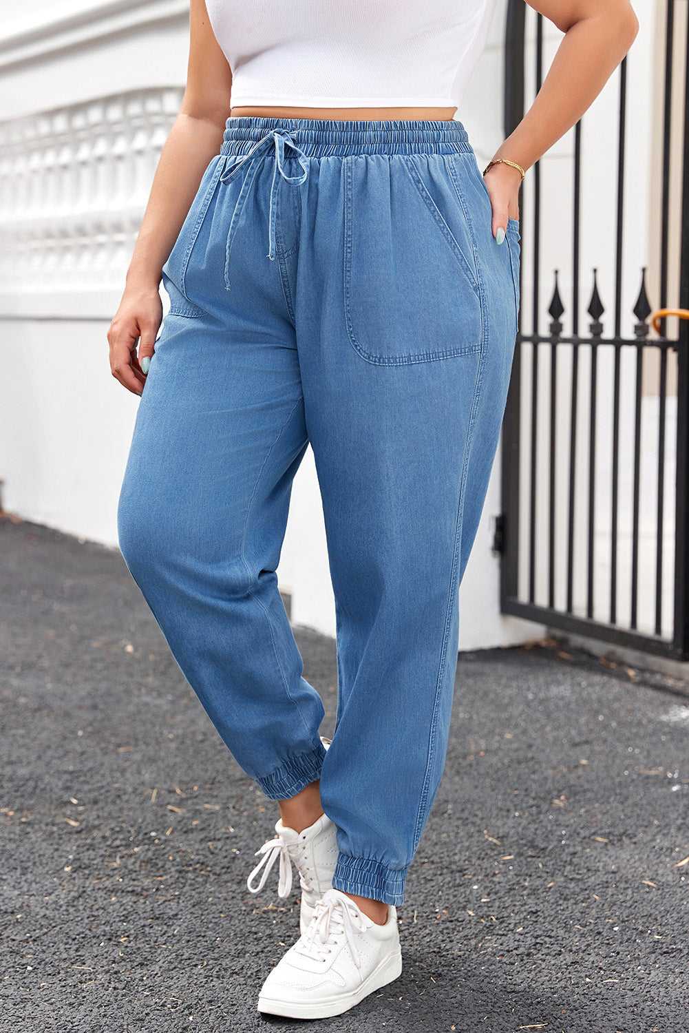 Side angle of Plus Size Blue Denim Joggers showing relaxed fit, drawstring waist, and tapered leg design for a flattering silhouette.