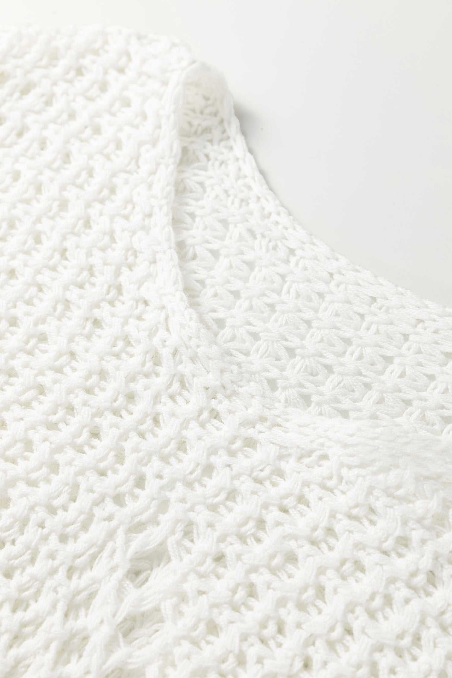 Close-up of white hollow knit jumper neckline, emphasizing the breathable open-knit texture and soft material.