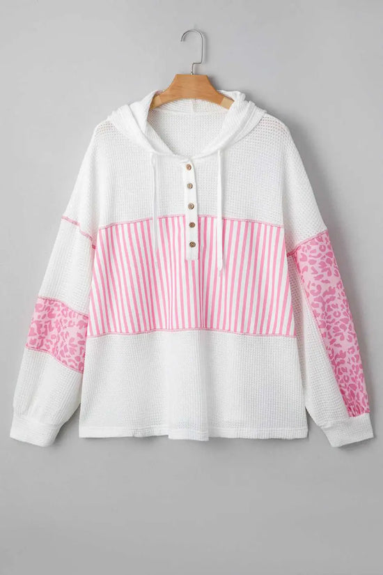 Flat lay of Curve Pink Leopard Stripe Waffle Hoodie for Women on hanger, displaying pink stripe and leopard patchwork on white waffle knit fabric.
