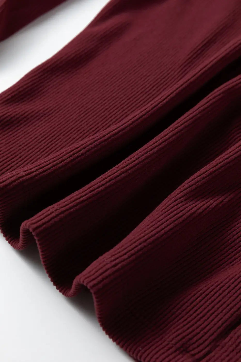 Hem detail of brown ribbed long sleeve crop top showing ribbed texture and clean stitching. Great for autumn and winter styling.