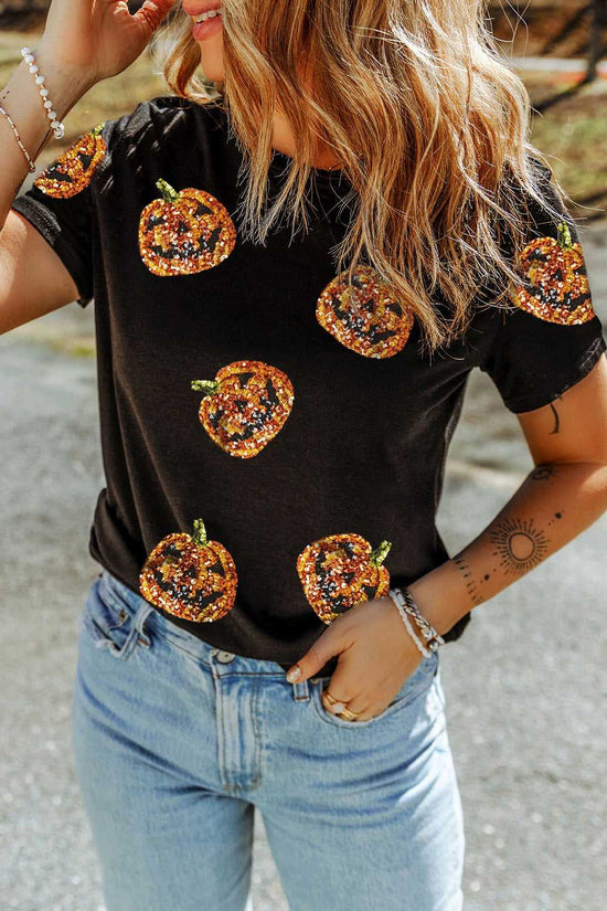 Person wearing a Sequin Pumpkin Face Halloween T-Shirt  - Halloween-themed pumpkin designs and blue jeans.