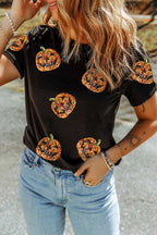 Person wearing a Sequin Pumpkin Face Halloween T-Shirt  - Halloween-themed pumpkin designs and blue jeans.