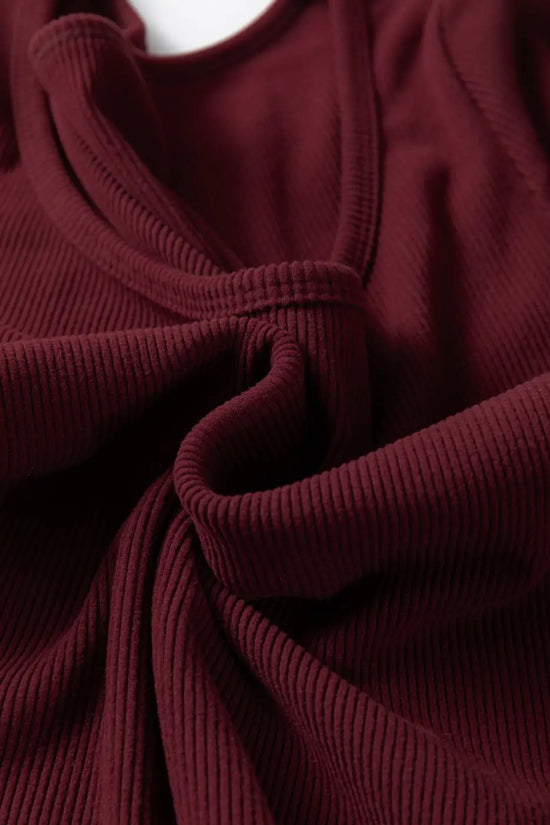 Detail of brown ribbed long sleeve crop top fabric twisted to show soft stretch knit. Ideal for casual and layering wear.