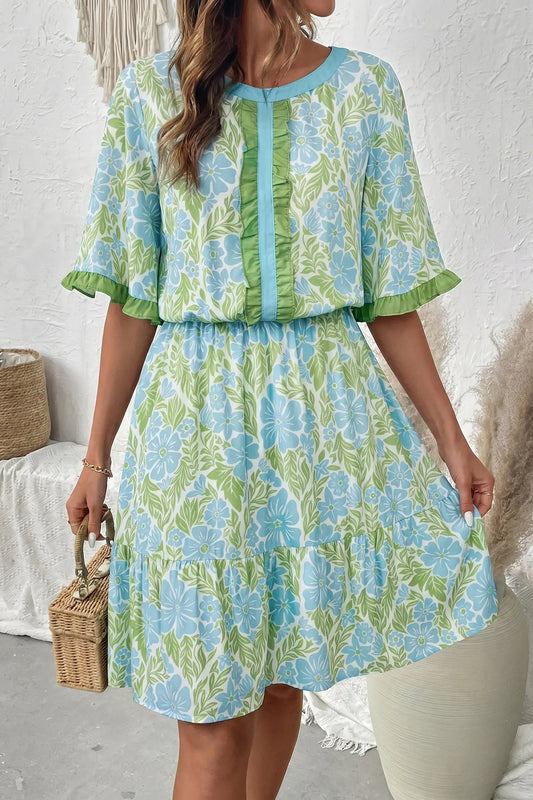 Woman wearing sky blue floral high waist ruffle mini dress with short sleeves, front view, Fashionfitz UK