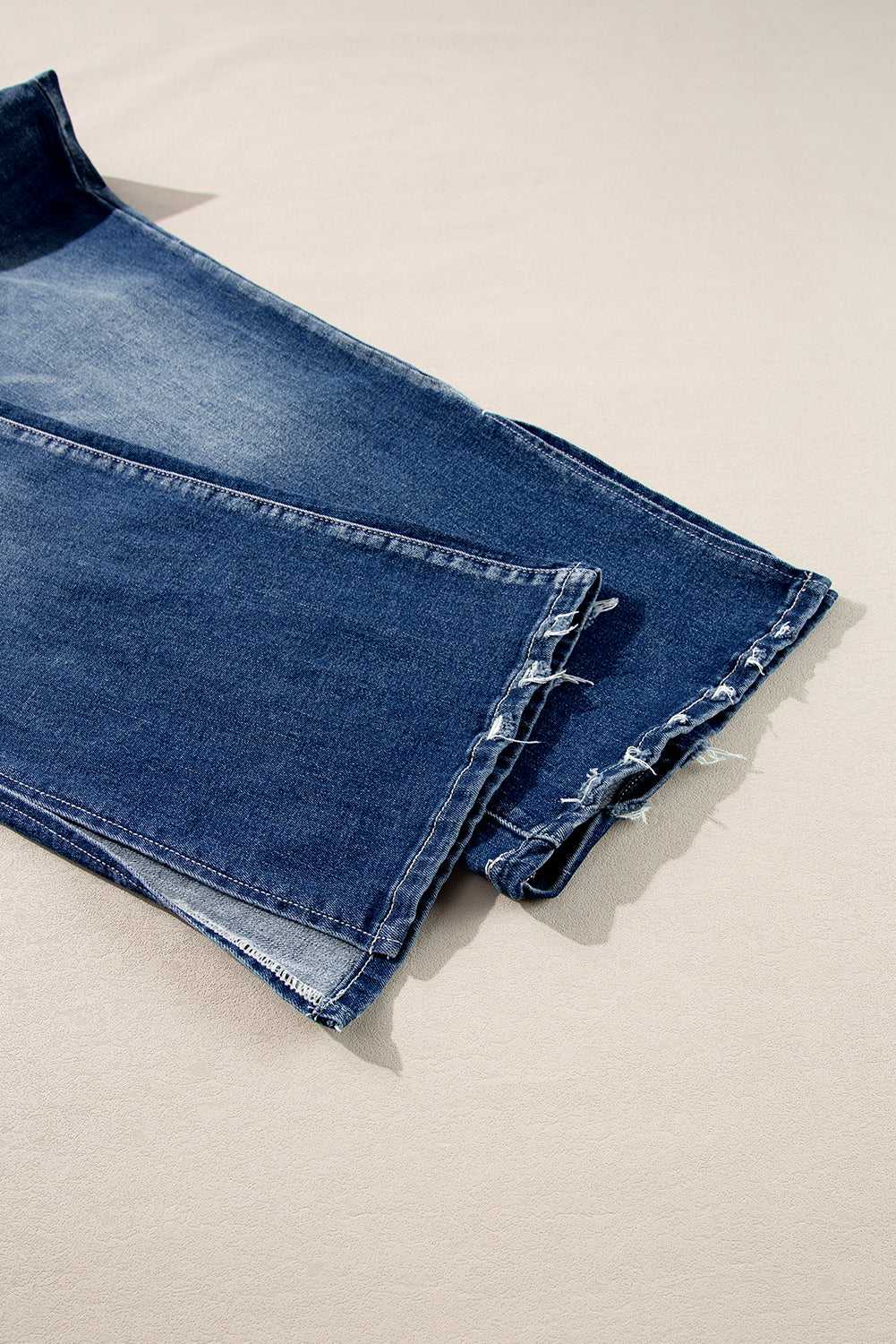Detailed view of Dirty Blue Side‑Slit Flare Jeans – Curve hem with frayed edges and side slit, emphasizing casual plus size style.