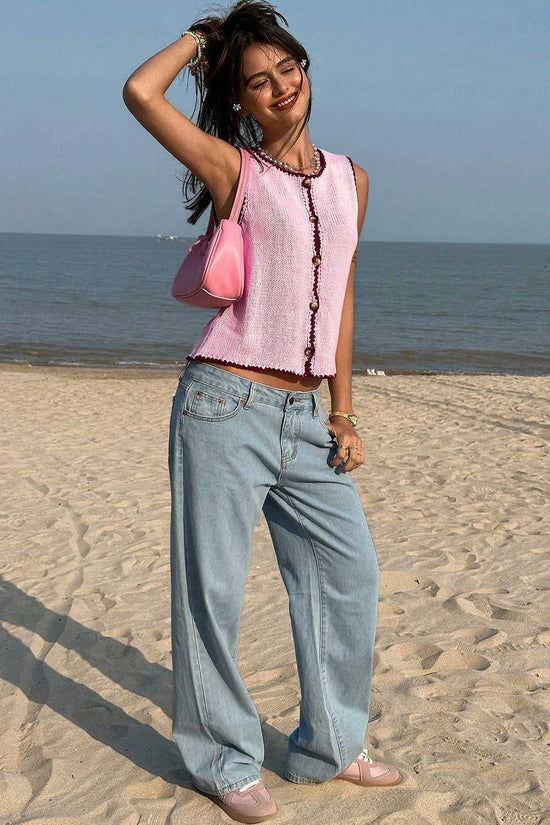 Model wearing pink contrast trim knit crop top with wide-leg jeans and pink accessories, styled for a casual summer beach look.