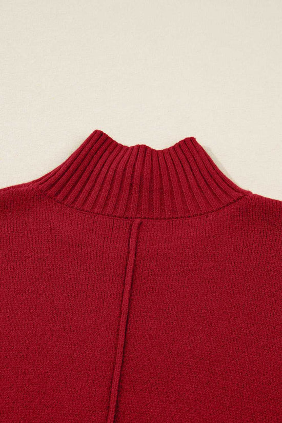 Close-up of ribbed high neckline on red knit jumper dress. Fine knit texture ideal for cozy winter wear in women’s sweater dresses.