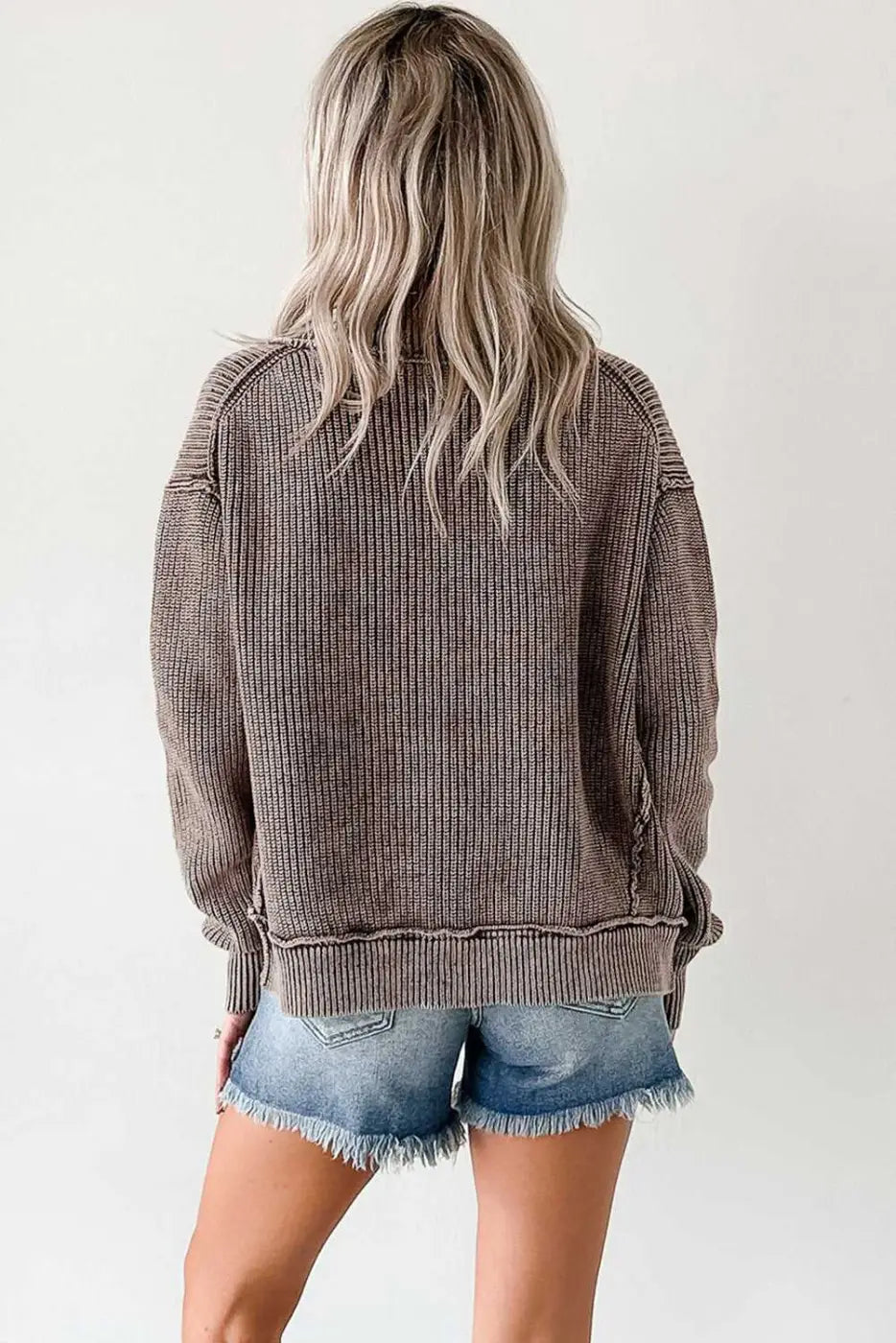 Back view of women's stonewash patchwork knit open cardigan in brown, styled with denim shorts for a casual fall look.