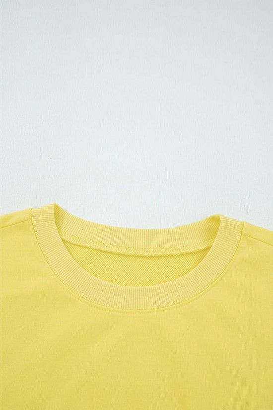 Close-up of yellow Drop Crop Set neckline with ribbed trim, highlighting quality construction and comfort-focused design.