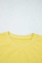 Close-up of yellow Drop Crop Set neckline with ribbed trim, highlighting quality construction and comfort-focused design.