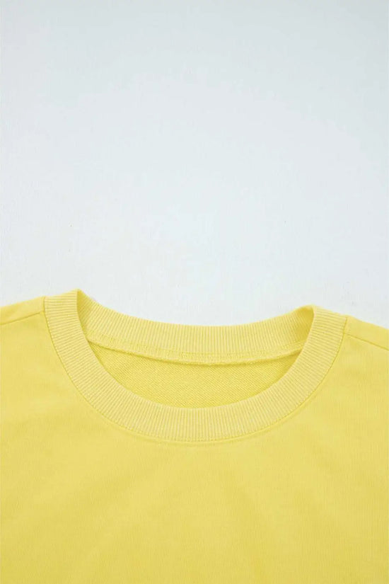 Close-up of yellow Drop Crop Set neckline with ribbed trim, highlighting quality construction and comfort-focused design.