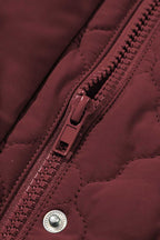 Close-up of zipper and snap button on burgundy Flower‑Quilted Winter Gilet, emphasizing secure closure and quality craftsmanship in winter vests.