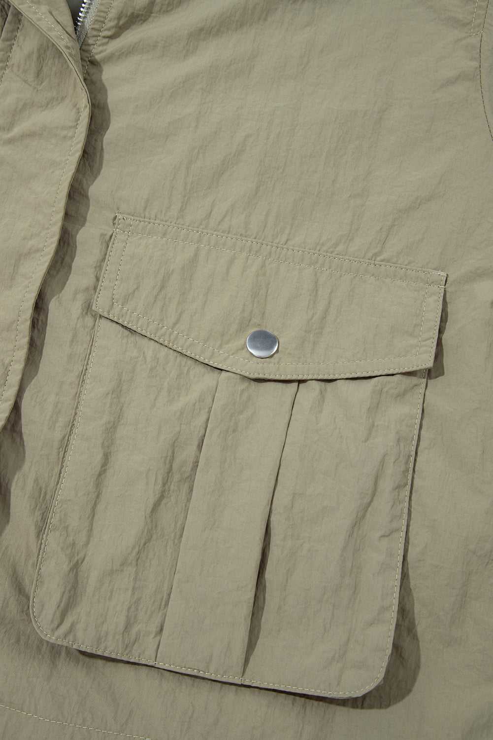 Front flap pocket with snap button on Cropped Hooded Utility Jacket, showcasing practical storage and solid color utility style.