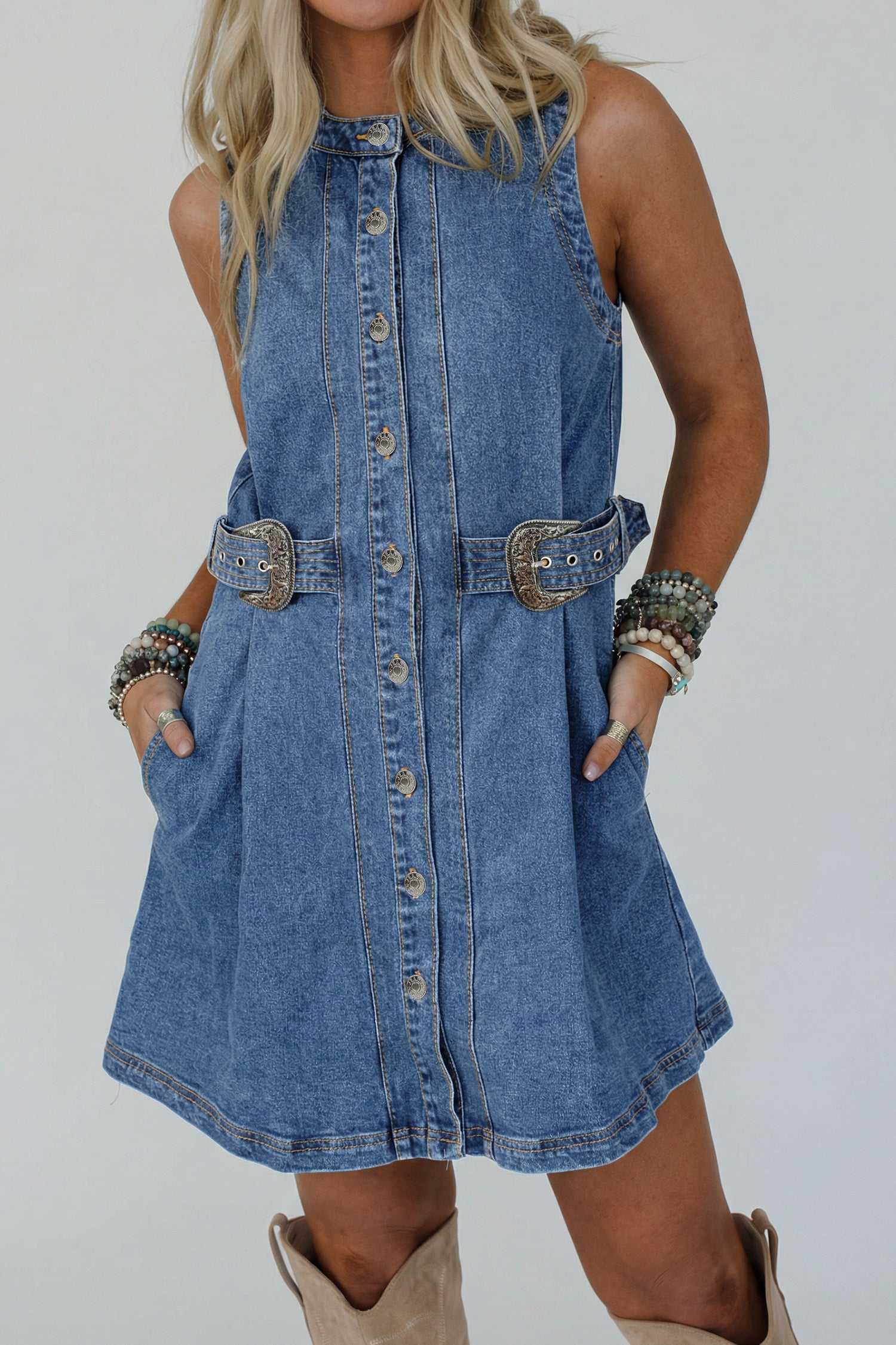 Western Belt Sleeveless Denim Dress styled with chunky bracelets and boots, highlighting the structured fit and belted waist for summer.