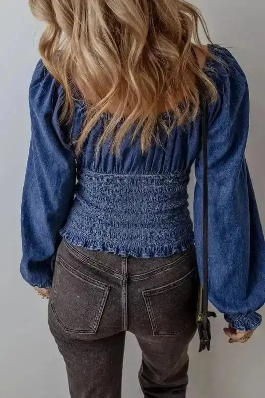 Back view of Blue Denim Smocked V-Neck Ruffle Sleeve Blouse showing cropped length and 95% cotton denim silhouette — Fashionfitz