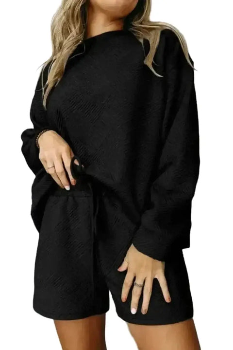 Woman wearing black textured ribbed loungewear set long sleeve top and drawstring shorts front view Fashionfitz UK