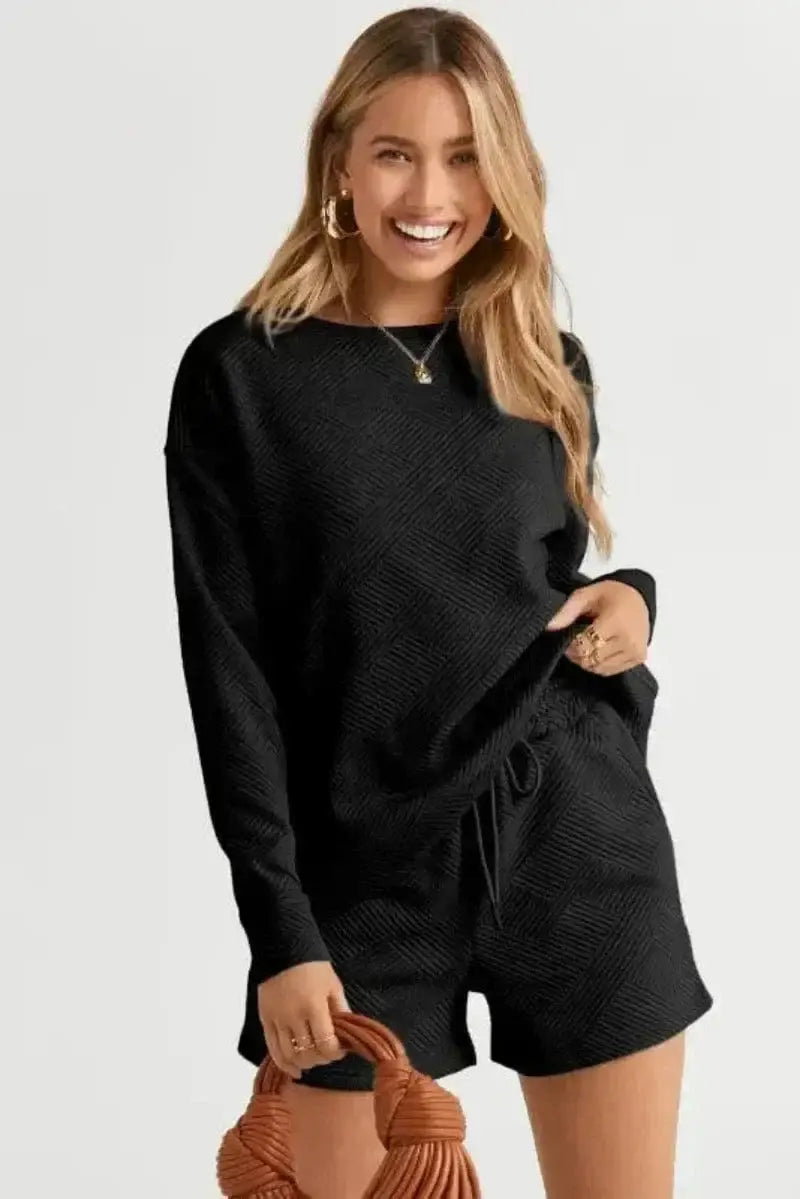 Flat lay of black ribbed loungewear set long sleeve top and drawstring shorts in matching textured fabric Fashionfitz UK
