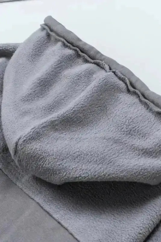 Interior view of gray drawstring hood on women's zip up jacket, highlighting fleece lining for warmth.