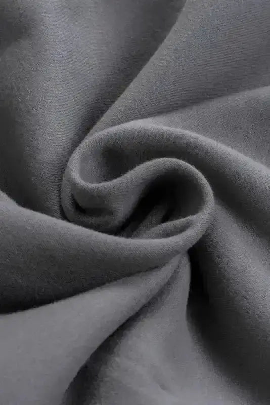 Close-up of gray fleece fabric used in women's zip up hooded jacket, showing soft and warm texture.