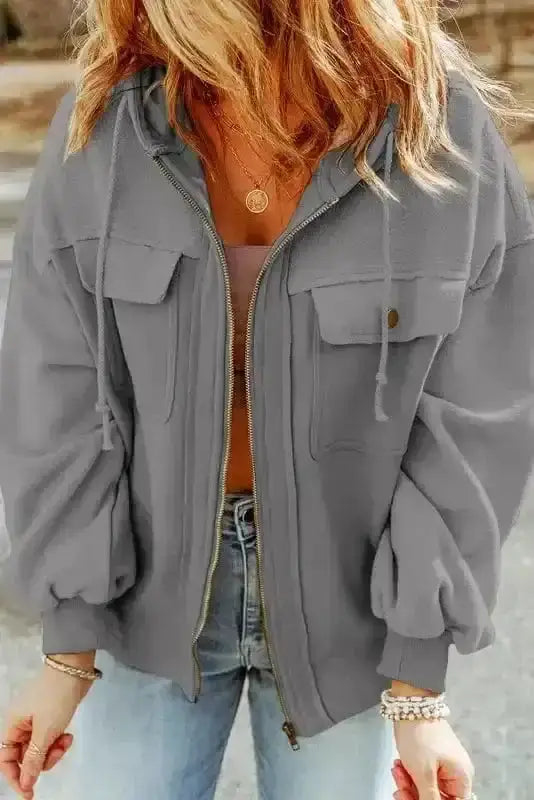 Gray women's hooded jacket with zip closure and flap pockets, ideal for cozy and casual winter layering.