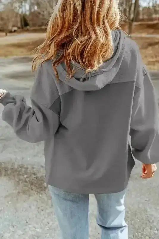 Back view of gray women's zip up hooded jacket with relaxed fit and cozy fleece fabric, perfect for fall to winter wear.