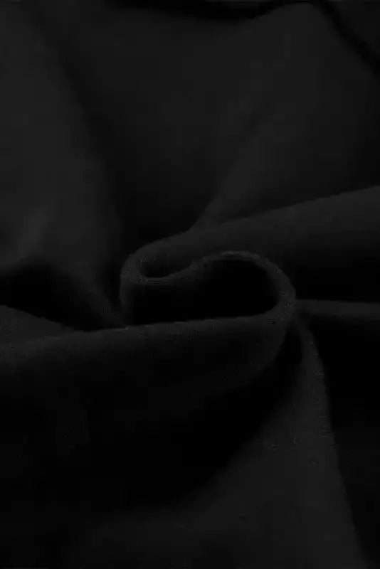Close-up of soft black fleece fabric used in the zip up hooded jacket for women, showcasing its cozy texture.
