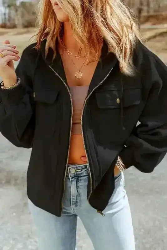 Black zip up hooded jacket women styled with jeans. Casual drawstring coat with flap pockets for fall and winter.