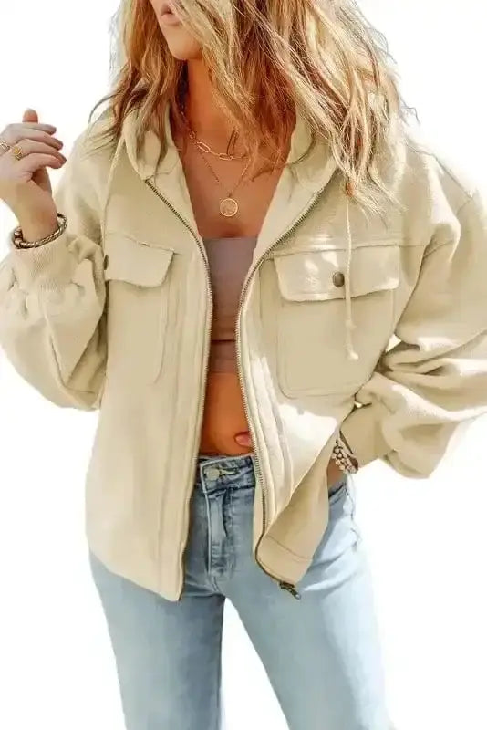 Beige zip up hooded jacket women styled with jeans. Casual fleece outerwear with flap pockets and drawstring hood.