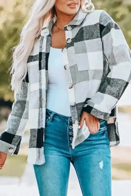 Gray and white plaid button down shacket for women, styled with white top and blue jeans for a casual outdoor look.