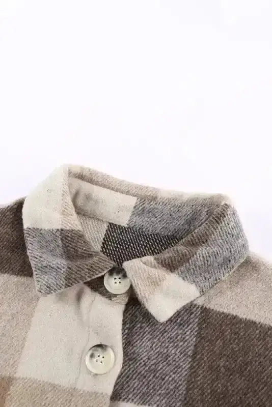 Close-up of collar and button details on plaid color block jacket, highlighting soft polyester fabric and neutral tones.