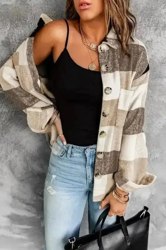 Women's plaid button down jacket in neutral color block design, layered over a black top for a cozy fall-to-winter outfit.
