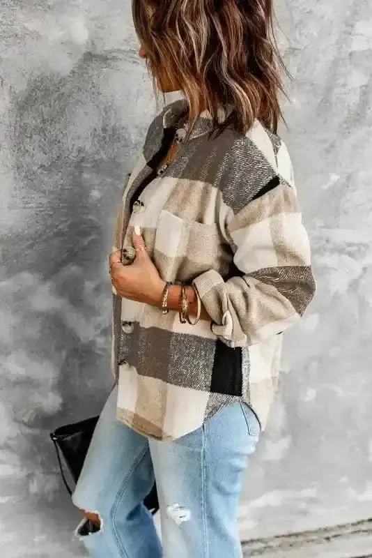 Side profile of khaki plaid shacket with chest pocket and curved hem, styled with distressed jeans for a trendy casual look.