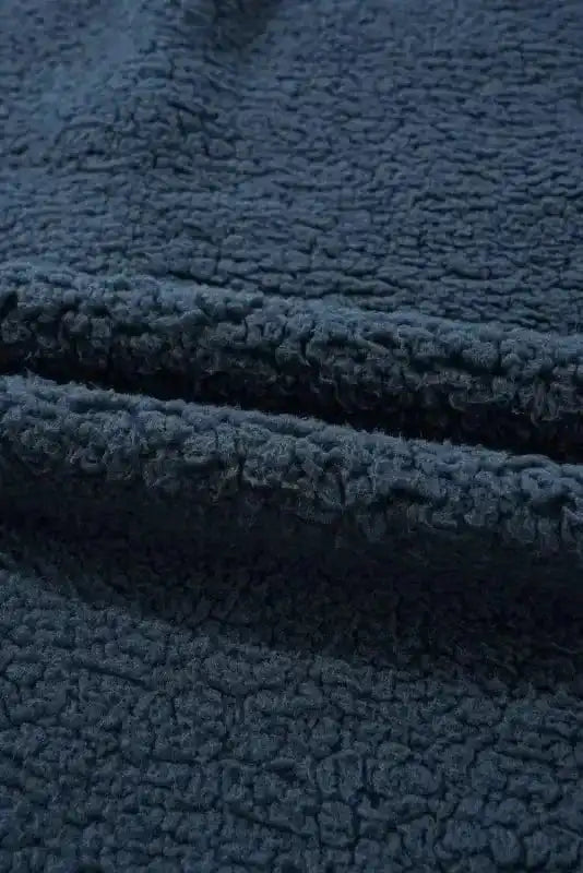 Detailed view of the soft fleece fabric on the blue teddy coat, highlighting its plush texture ideal for cold weather comfort.
