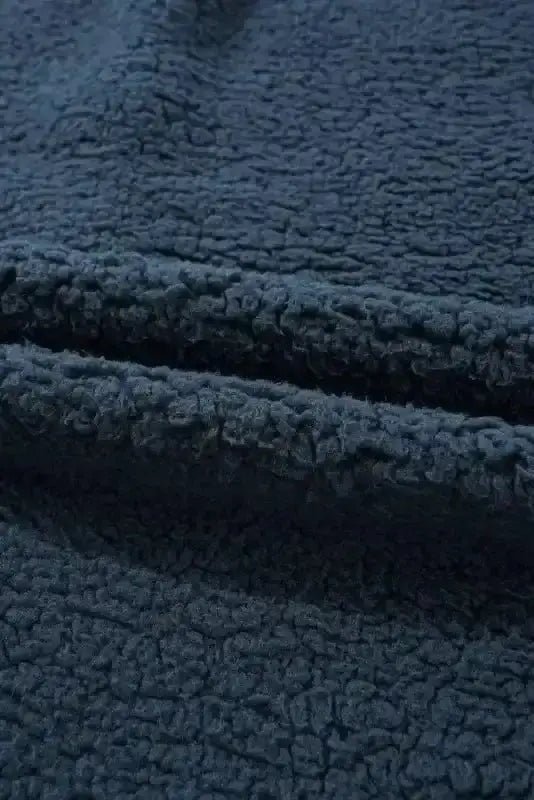 Detailed view of the soft fleece fabric on the blue teddy coat, highlighting its plush texture ideal for cold weather comfort.