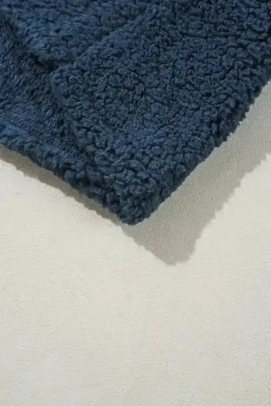 Hem detail of the blue teddy coat showing soft fleece texture and clean stitching, ideal for casual winter wear.