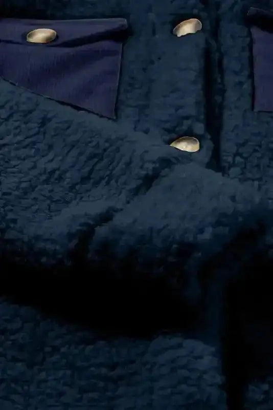 Close-up of the sleeve and button placket on the blue teddy coat, highlighting the soft fleece material and gold-tone buttons.