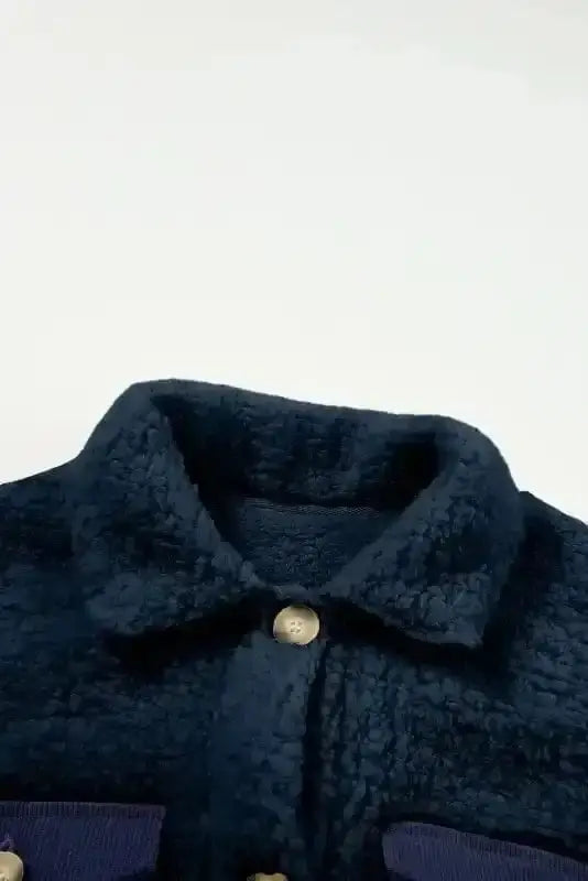 Detailed view of the buttoned collar on the cozy blue teddy coat, showcasing its warm fleece fabric and neat stitching.