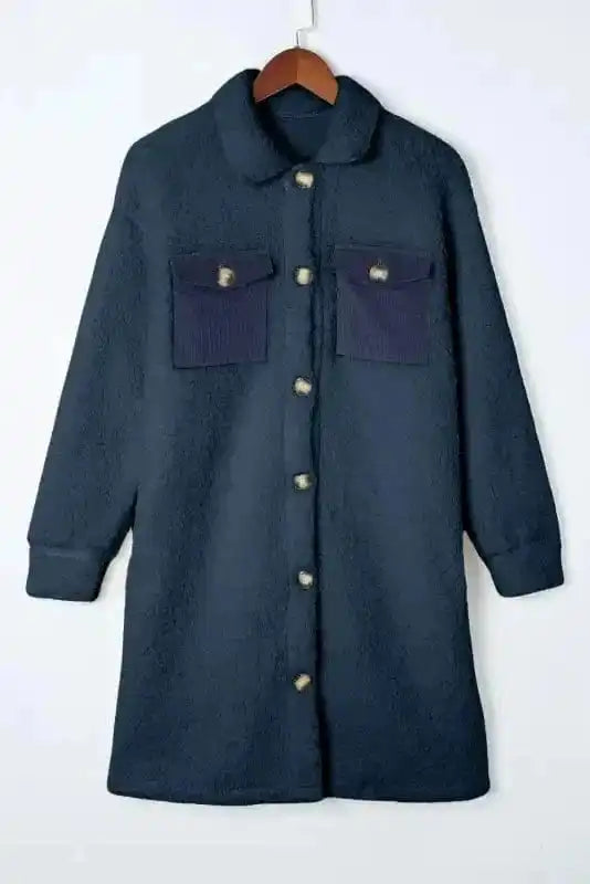 Flat lay of cozy blue teddy coat with front buttons and contrast chest pockets, highlighting its soft fleece material and winter-ready design.