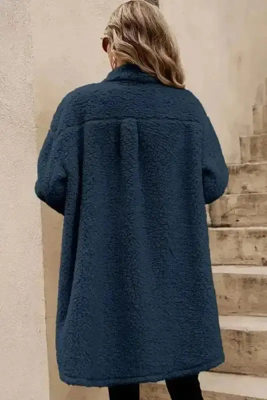Back view of the cozy blue teddy coat showcasing its soft fleece texture and relaxed fit, perfect for cold-weather layering.