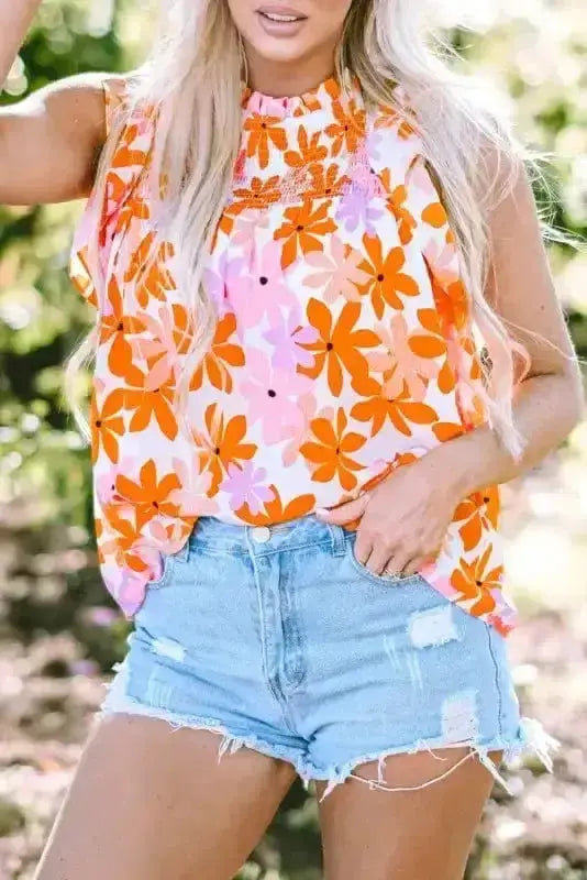 Detailed front view of Orange Smocked Floral Top highlighting smocked neckline and vibrant floral pattern. Lightweight and breezy blouse.