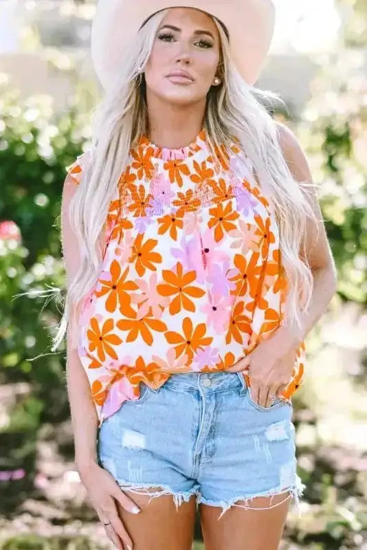 Front close-up of Orange Smocked Floral Top with bold orange and pink floral print and smocked neckline. FashionFitz summer blouse.