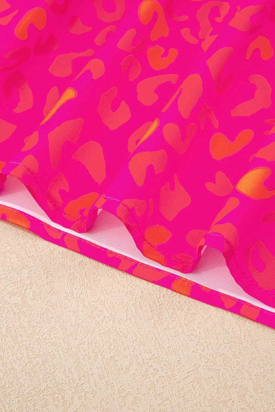 Close-up of puff sleeves and round neckline on a pink leopard print top.