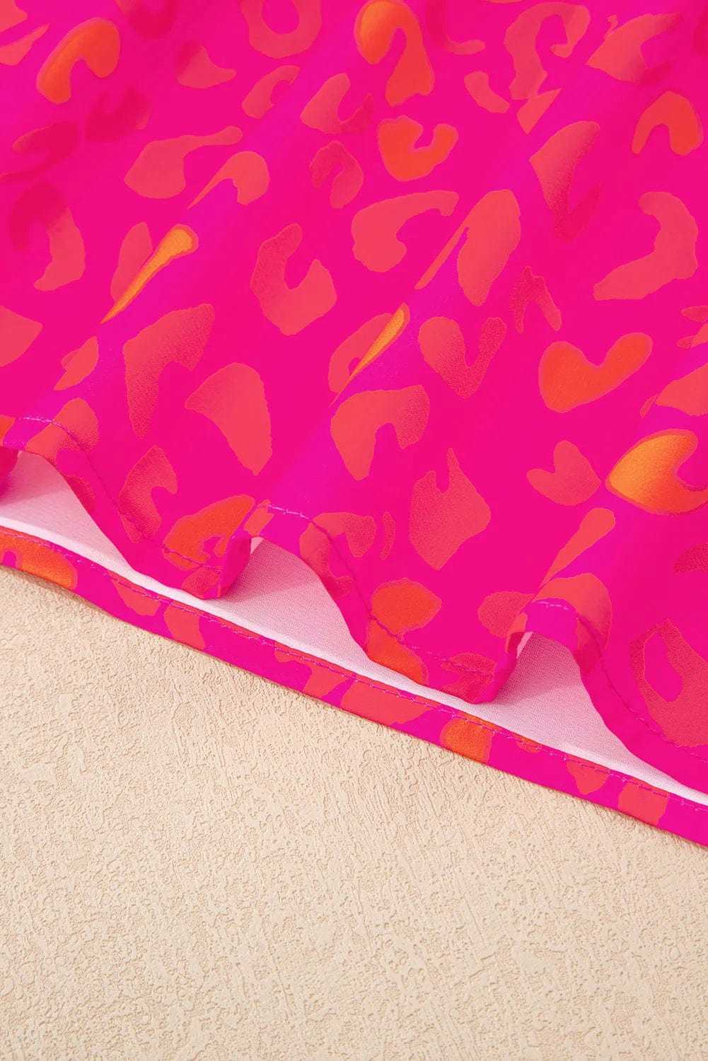 Close-up of puff sleeves and round neckline on a pink leopard print top.