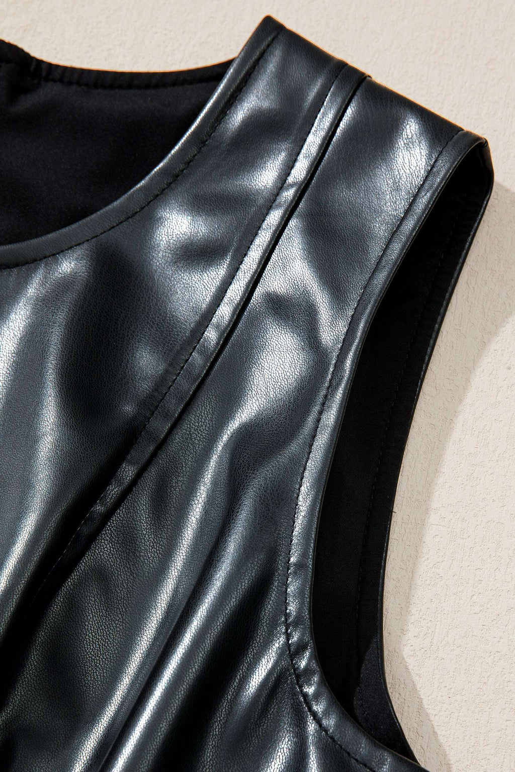 Shoulder detail of Ladies Black Faux Leather Mini Dress | FashionFitz highlighting seam lines and glossy faux leather texture.