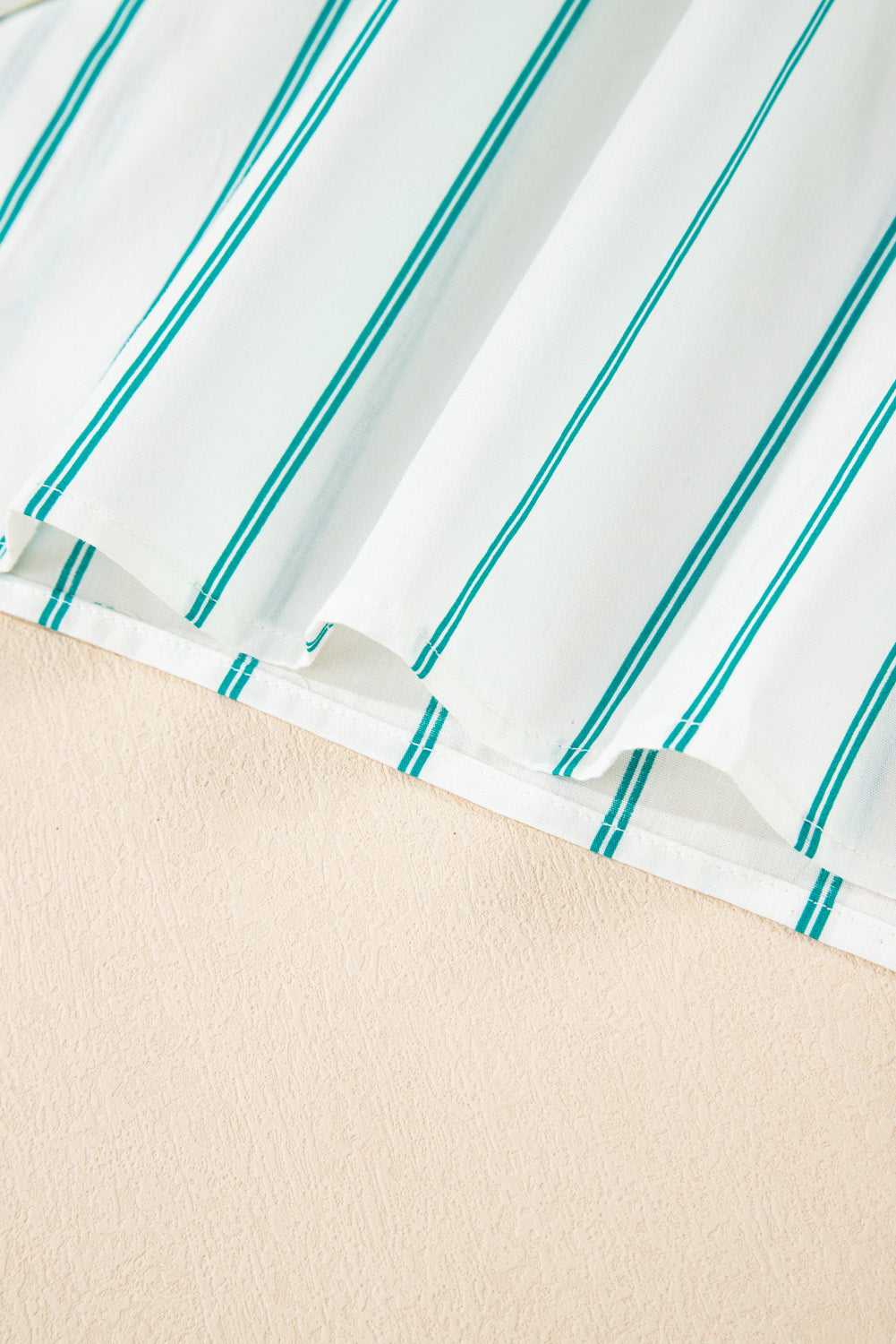 Close-up of a fabric with turquoise stripes on a white background