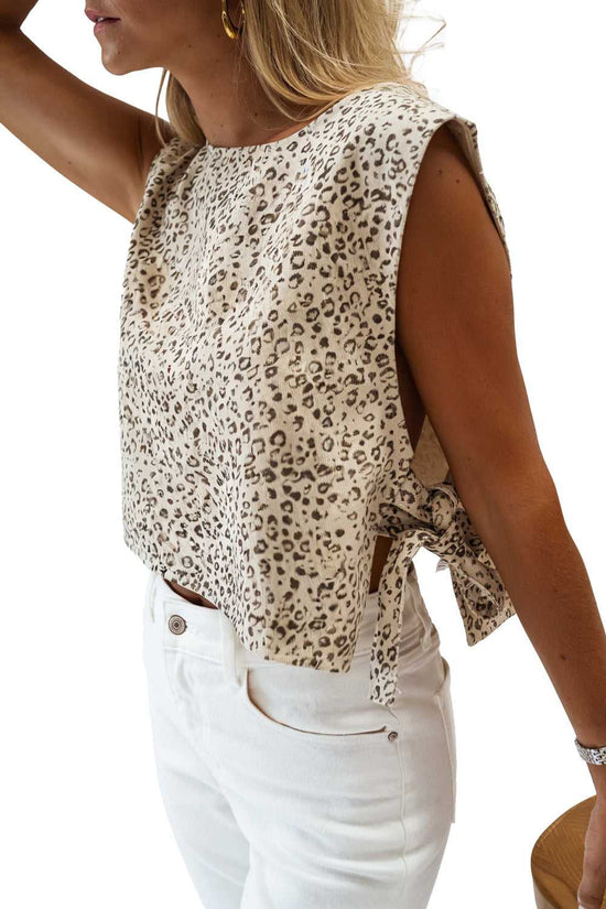 Apricot leopard knit tank top in cropped style with sleeveless design and side ties, paired with white pants for a trendy summer look.