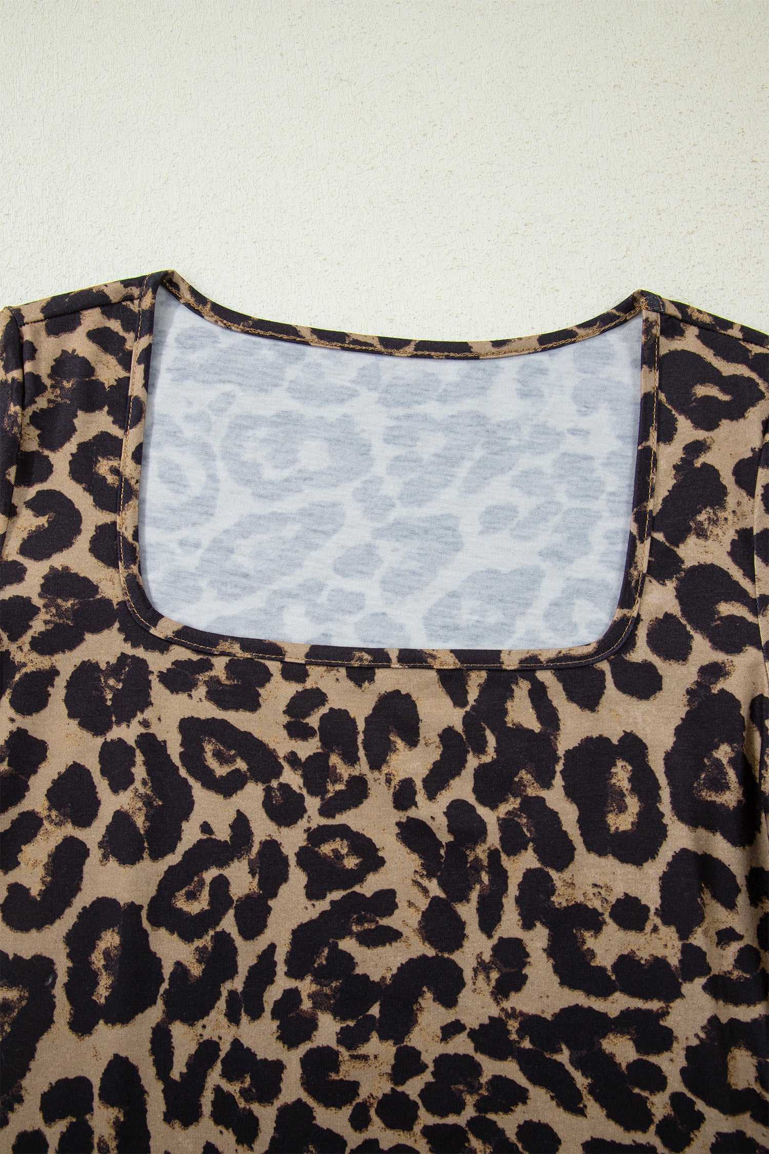Close-up of leopard print slim long sleeve top neckline, highlighting soft stretch fabric and detailed stitching.